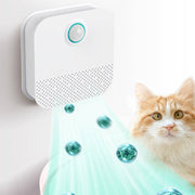 Automatic pet odor purifier mounted on wall deodorizing air near a cat and litter box area
